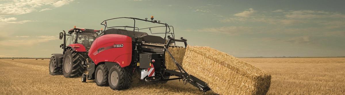 A Case IH baler that's bundling hay in a dry field